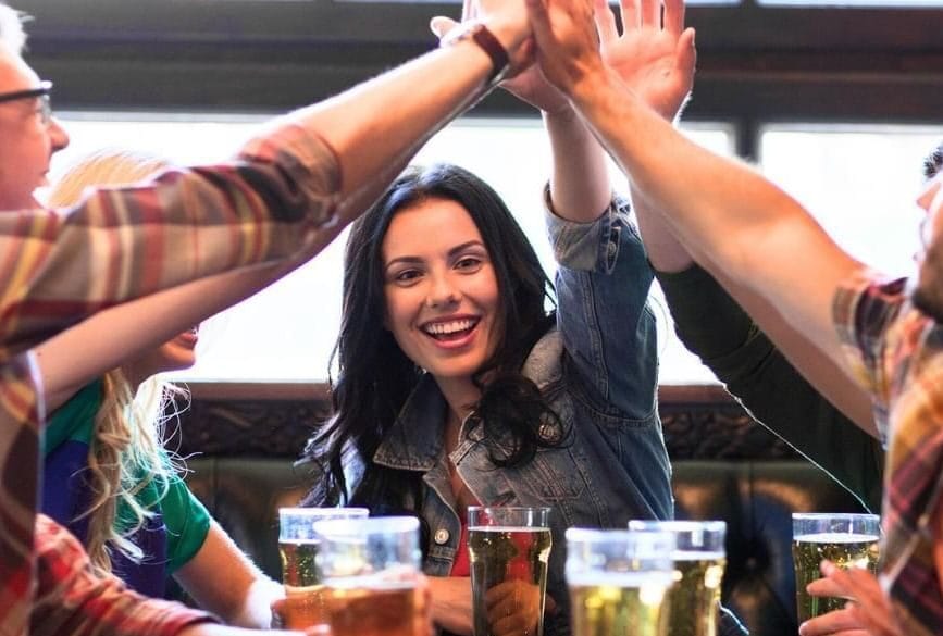 A table of people giving a high five at a quiz night